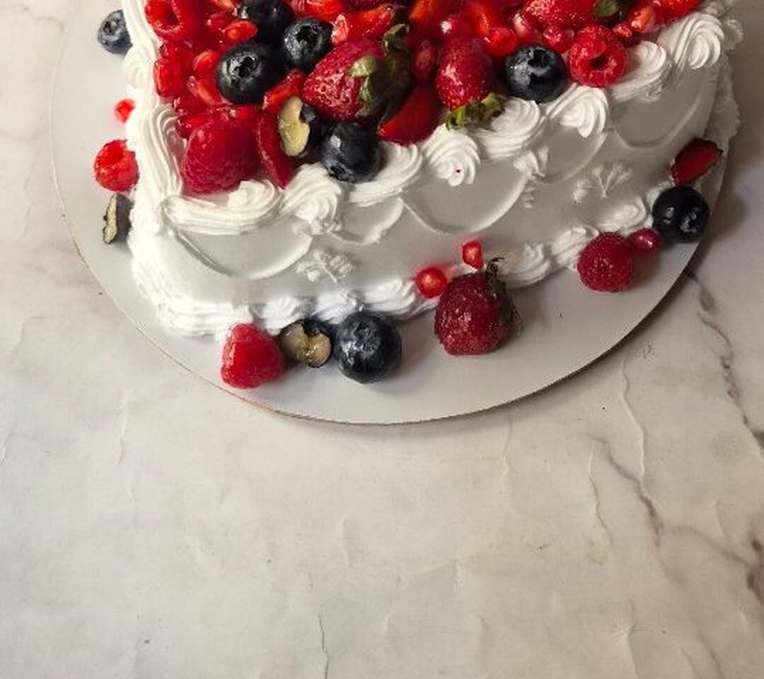 Fresh berries and cream swirls on a vintage celebration cake