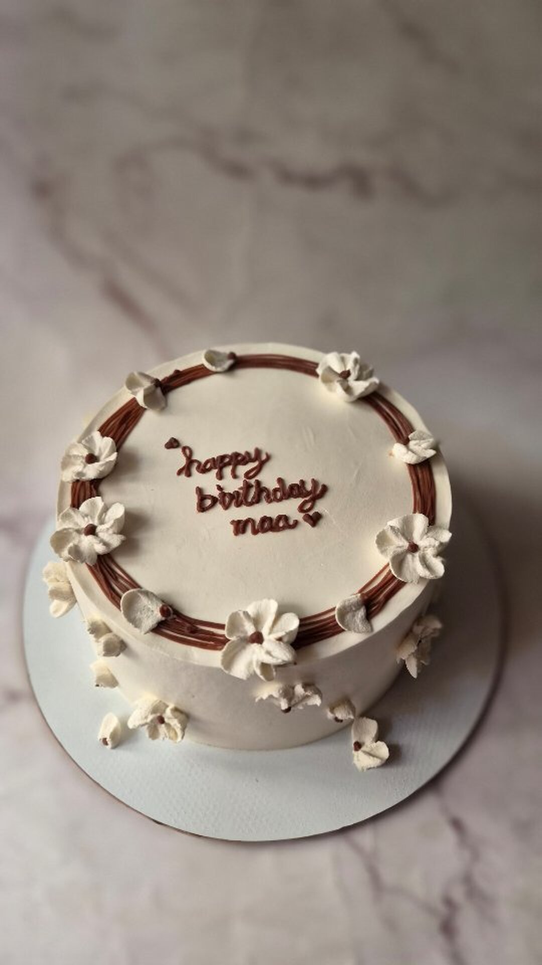 White celebration cake with hand-piped happy birthday